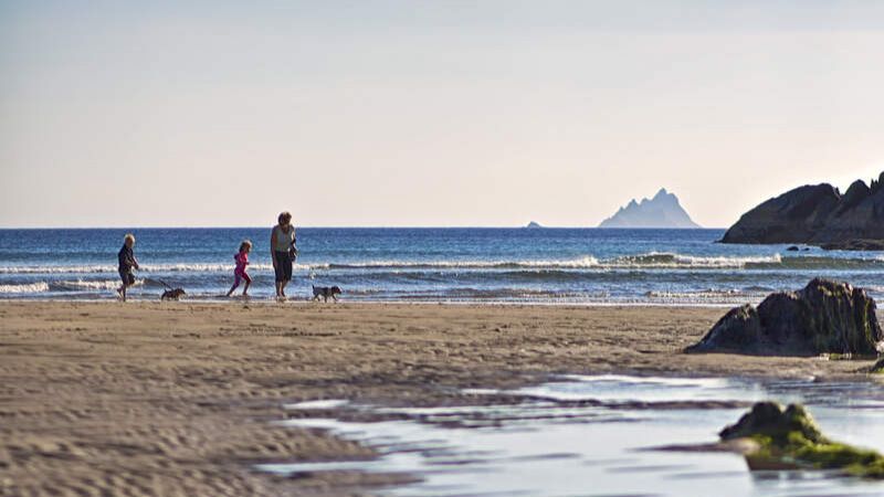 Family walking Ballinskelligs Beach with Skellig Michael in the background